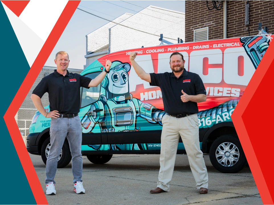 Two men in matching black shirts stand in front of a company van with a robot graphic, smiling and holding up a pair of red pliers.